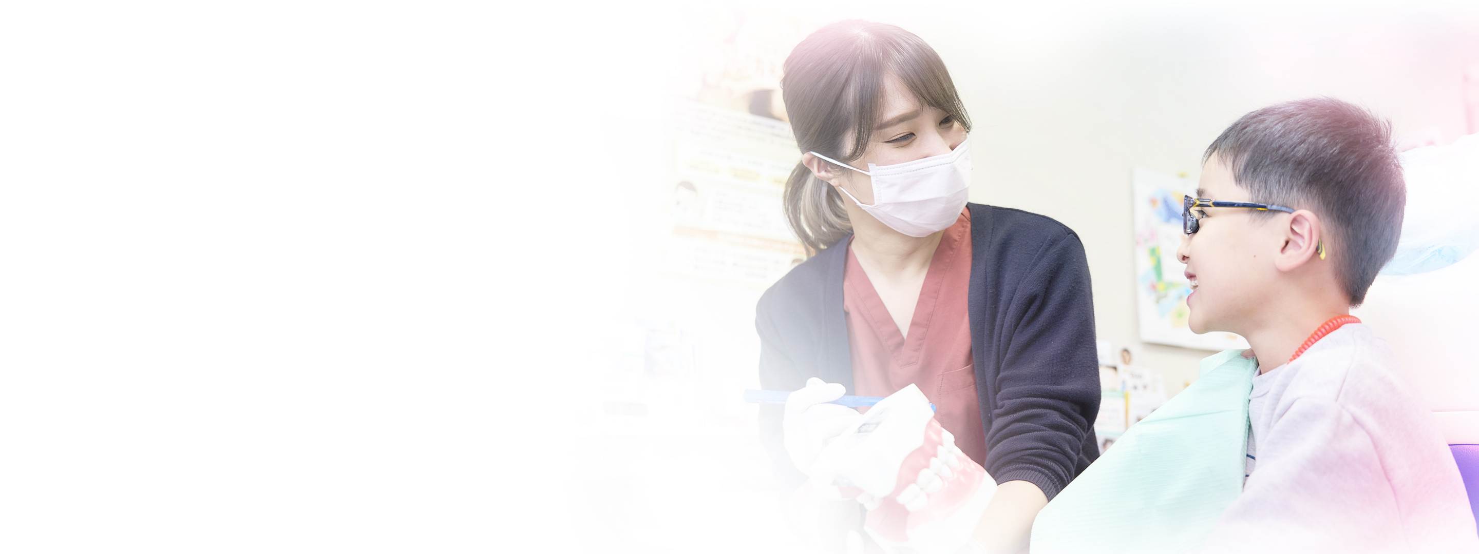 歯科衛生士と笑顔の子どもが矯正治療について話している様子