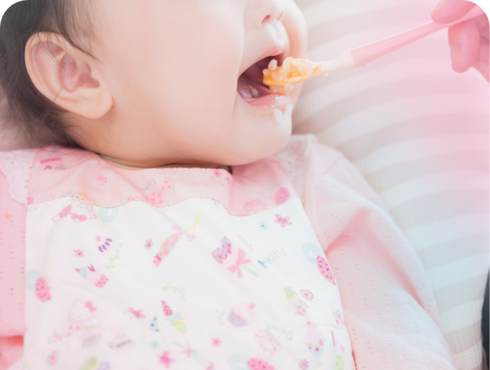 幼児がスプーンを口に運んでいる様子